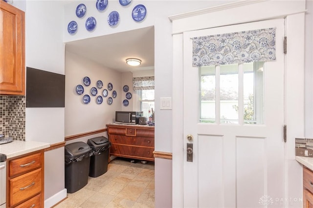 2817 Whittier Ave, Dayton, OH 45420 - kitchen with tasteful backsplash, light countertops, brown cabinetry, and stainless steel microwave