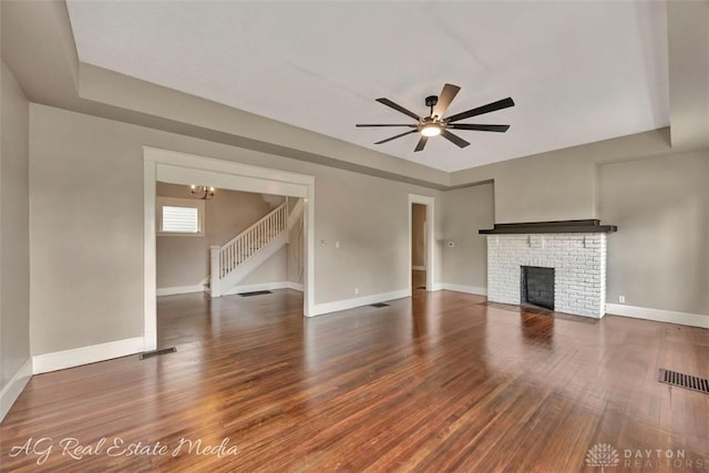 200 Garfield St, Middletown, OH 45044 - unfurnished living room with stairs, wood finished floors, ceiling fan, a fireplace, and a chandelier