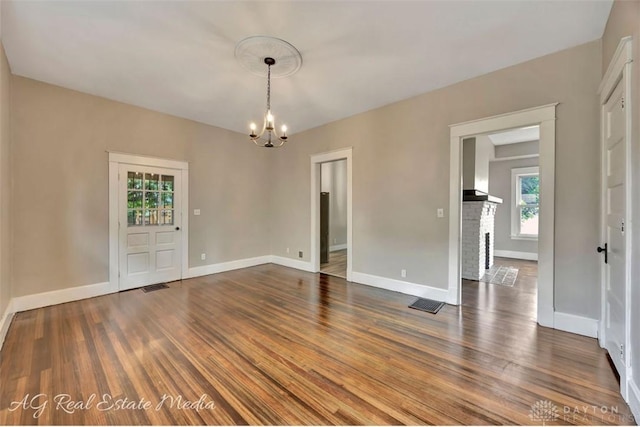 200 Garfield St, Middletown, OH 45044 - empty room with a chandelier, wood finished floors, and a brick fireplace