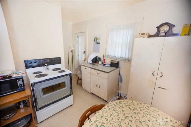 2107 Woodlawn Ave, Middletown, OH 45044 - kitchen with white electric range oven, black microwave, light flooring, and light countertops