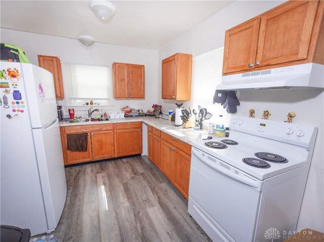 2107 Woodlawn Ave, Middletown, OH 45044 - kitchen with white appliances, under cabinet range hood, wood finished floors, light countertops, and brown cabinetry