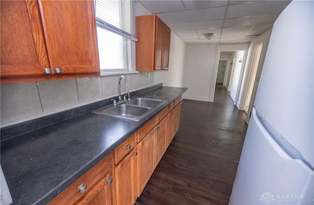 2107 Woodlawn Ave, Middletown, OH 45044 - kitchen with freestanding refrigerator, dark countertops, dark wood-style flooring, brown cabinets, and a drop ceiling