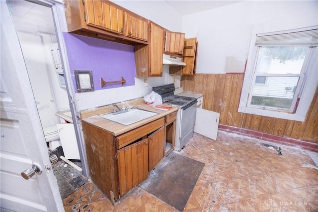 2107 Woodlawn Ave, Middletown, OH 45044 - kitchen featuring white electric range, under cabinet range hood, wood walls, brown cabinetry, and light countertops