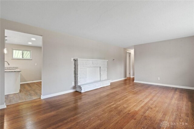 40 Rosewood Dr, Springboro, OH 45066 - unfurnished living room featuring wood finished floors and a stone fireplace