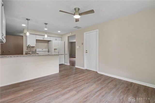 40 Rosewood Dr, Springboro, OH 45066 - kitchen with white refrigerator with ice dispenser, stove, a ceiling fan, wood finished floors, and recessed lighting