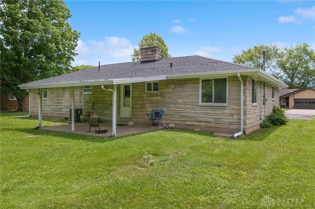 40 Rosewood Dr, Springboro, OH 45066 - back of property with stone siding, a chimney, a patio area, and a yard