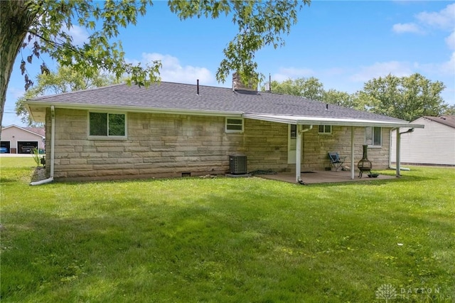 40 Rosewood Dr, Springboro, OH 45066 - back of house featuring stone siding, a patio, a lawn, and a chimney