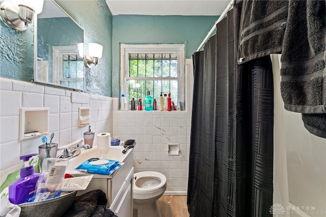 3558 Stanford Pl, Dayton, OH 45406 - bathroom with tile walls, wood finished floors, vanity, a shower with curtain, and a wainscoted wall