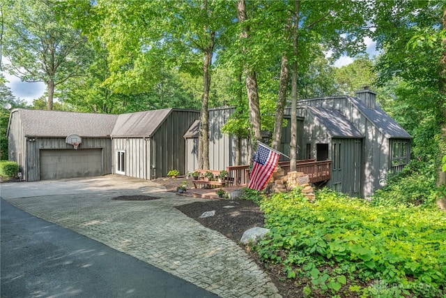 1839 Quail Hollow Rd, Washington Twp, OH 45459 - view of front of home featuring driveway, a garage, an outdoor structure, a chimney, and roof with shingles