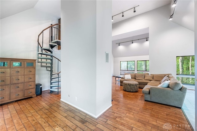 1839 Quail Hollow Rd, Washington Twp, OH 45459 - living area with track lighting, high vaulted ceiling, stairs, and light wood-style floors