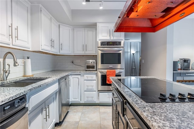 1839 Quail Hollow Rd, Washington Twp, OH 45459 - kitchen featuring appliances with stainless steel finishes, extractor fan, white cabinets, backsplash, and light tile patterned flooring