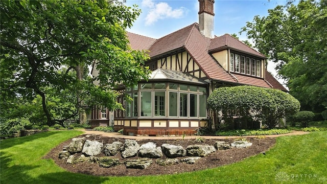 1160 Lytle Ln, Kettering, OH 45409 - rear view of house with a sunroom, a chimney, and a yard