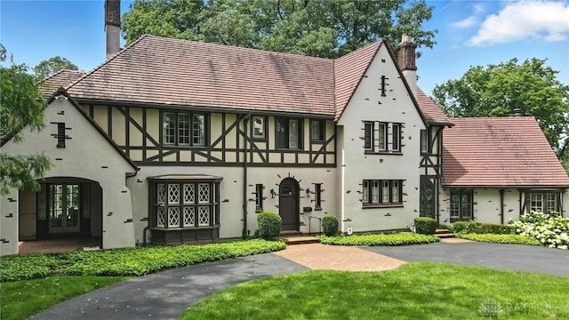 1160 Lytle Ln, Kettering, OH 45409 - tudor home featuring a chimney, stucco siding, and french doors