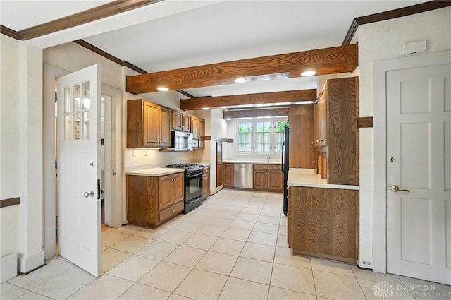 1160 Lytle Ln, Kettering, OH 45409 - kitchen with black appliances, light tile patterned floors, light countertops, brown cabinets, and beamed ceiling
