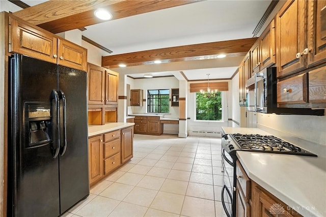1160 Lytle Ln, Kettering, OH 45409 - kitchen featuring black fridge, stainless steel gas range, light tile patterned flooring, brown cabinets, and a chandelier