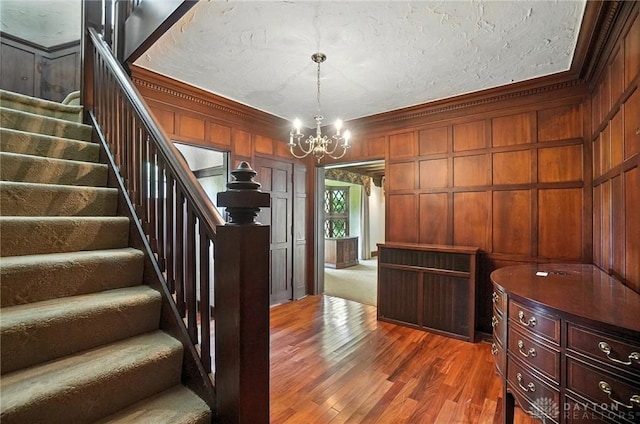 1160 Lytle Ln, Kettering, OH 45409 - stairway with a chandelier, ornamental molding, wood finished floors, and wooden walls