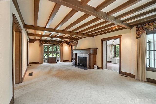 1160 Lytle Ln, Kettering, OH 45409 - unfurnished living room with healthy amount of natural light, beamed ceiling, a tile fireplace, and carpet floors