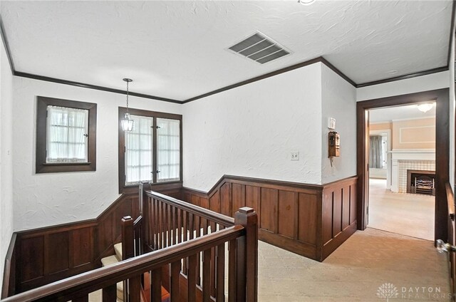 1160 Lytle Ln, Kettering, OH 45409 - corridor with an upstairs landing, a wainscoted wall, ornamental molding, a textured ceiling, and wooden walls