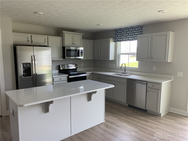 6655 Roycroft Dr, Middletown, OH 45042 - kitchen featuring stainless steel appliances, a center island, light wood-style floors, a breakfast bar, and light countertops
