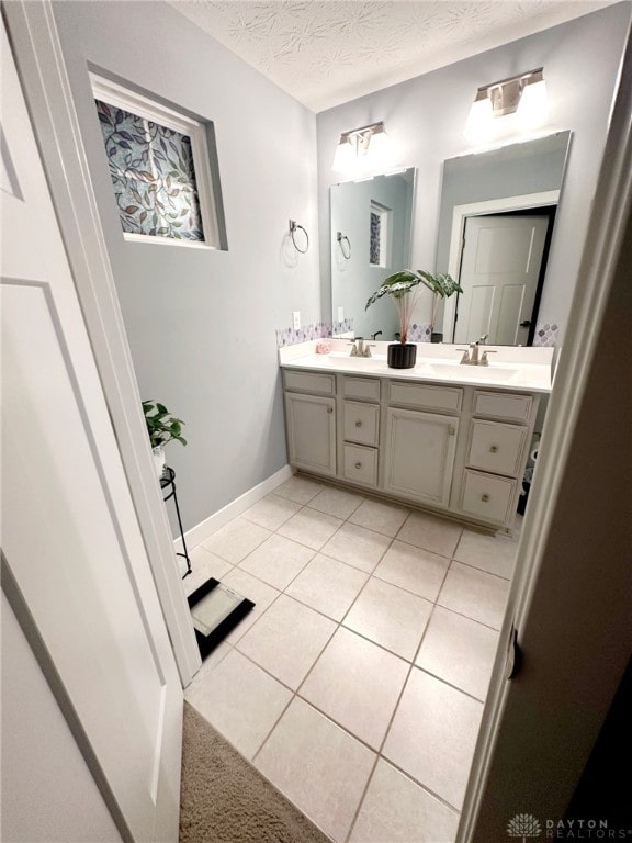 6655 Roycroft Dr, Middletown, OH 45042 - full bathroom with double vanity, tile patterned floors, and a textured ceiling