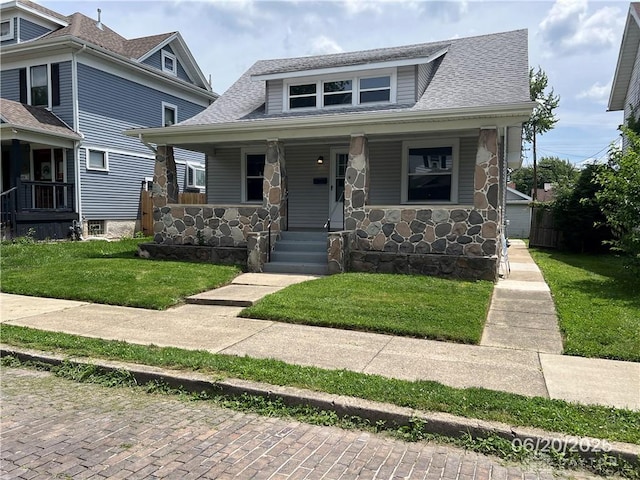 1410 Carlisle Ave, Dayton, OH 45420 - bungalow-style house with stone siding, a porch, a front yard, and roof with shingles
