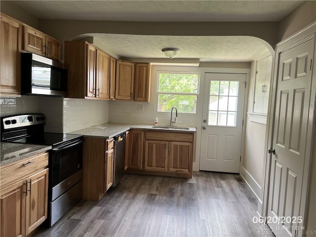 1410 Carlisle Ave, Dayton, OH 45420 - kitchen with stainless steel appliances, dark wood finished floors, backsplash, light stone countertops, and arched walkways
