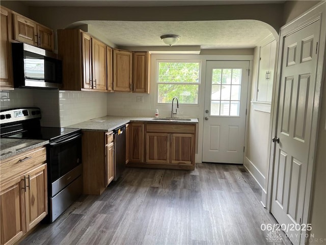 1410 Carlisle Ave, Dayton, OH 45420 - kitchen with appliances with stainless steel finishes, wood finished floors, backsplash, and a textured ceiling
