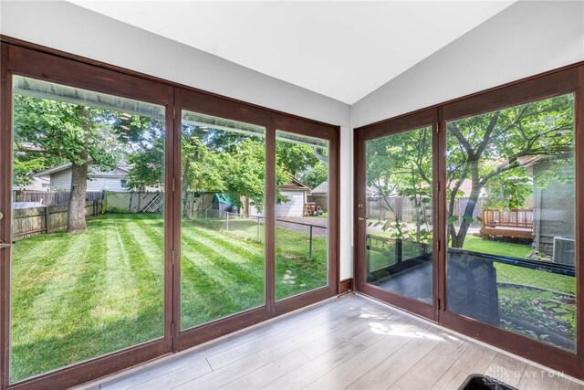 1525 Crescent Blvd, Kettering, OH 45409 - unfurnished sunroom featuring vaulted ceiling, a deck, and wood finished floors