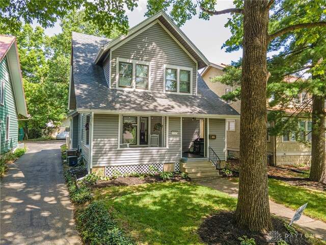 1525 Crescent Blvd, Kettering, OH 45409 - view of front facade featuring covered porch, a shingled roof, and a front lawn