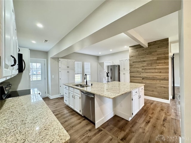 356 Old St Unit 122, Clearcreek Twp, OH 45036 - kitchen with appliances with stainless steel finishes, white cabinets, a kitchen island with sink, recessed lighting, and wooden walls