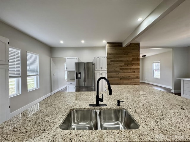 356 Old St Unit 122, Clearcreek Twp, OH 45036 - kitchen with stainless steel fridge with ice dispenser, white cabinets, light stone counters, recessed lighting, and beam ceiling
