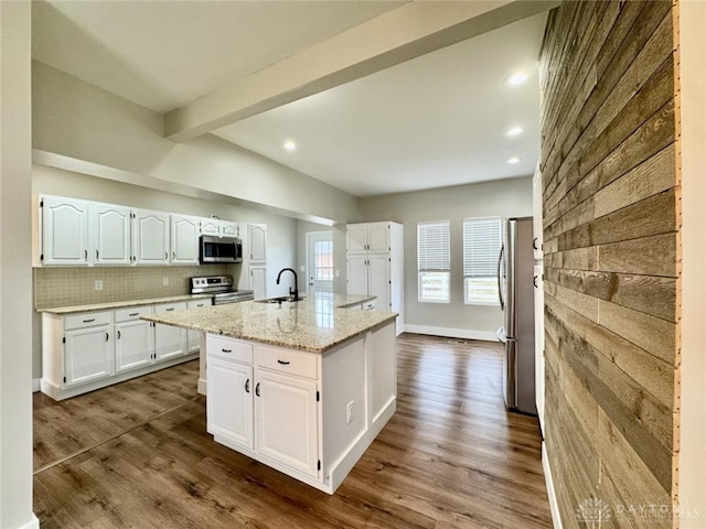 356 Old St Unit 122, Clearcreek Twp, OH 45036 - kitchen featuring appliances with stainless steel finishes, white cabinets, beam ceiling, an island with sink, and recessed lighting