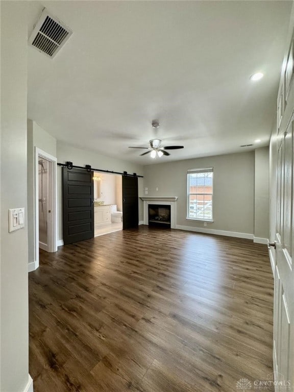356 Old St Unit 122, Clearcreek Twp, OH 45036 - unfurnished living room with ceiling fan, dark wood-style floors, a barn door, a fireplace, and recessed lighting
