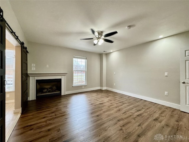 356 Old St Unit 122, Clearcreek Twp, OH 45036 - unfurnished living room with ceiling fan, dark wood-type flooring, a barn door, a fireplace, and recessed lighting