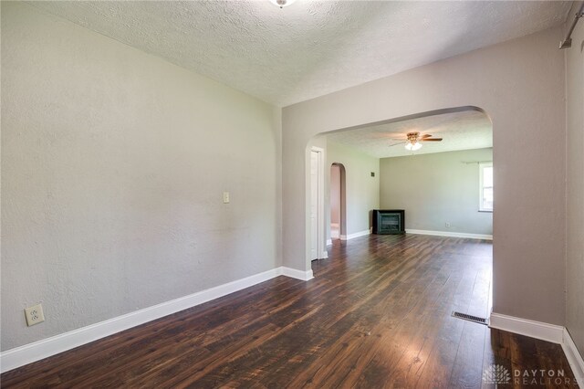 732 Central Ave, Franklin, OH 45005 - unfurnished living room featuring arched walkways, dark wood finished floors, ceiling fan, and a textured ceiling