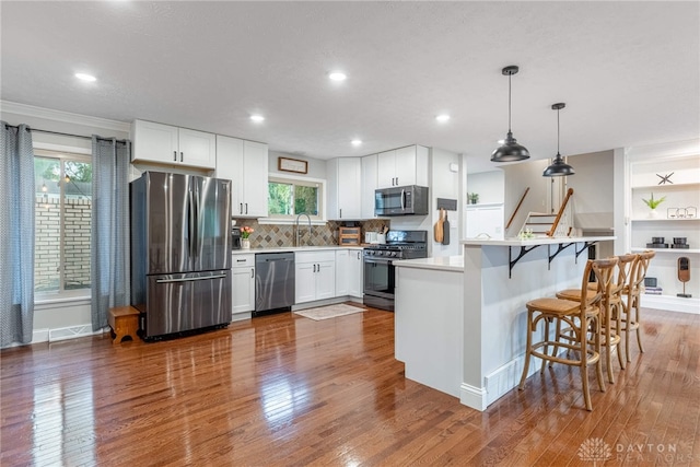4629 Wicklow Dr, Middletown, OH 45042 - kitchen featuring appliances with stainless steel finishes, wood finished floors, white cabinets, pendant lighting, and recessed lighting