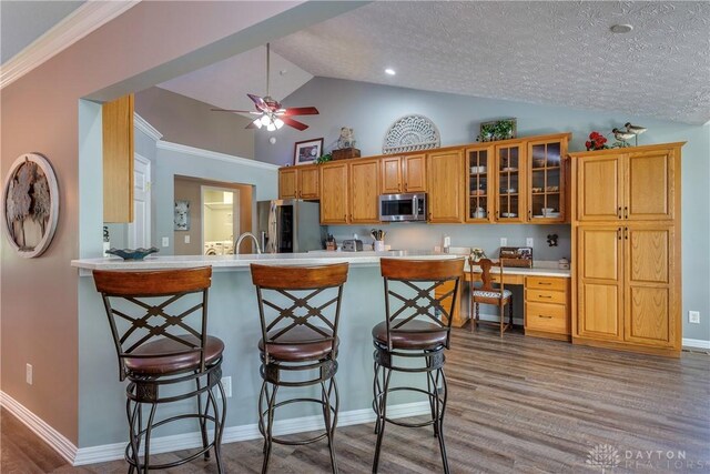 1210 Greystone Cir, Dayton, OH 45414 - kitchen with stainless steel appliances, vaulted ceiling, a kitchen breakfast bar, light countertops, and ceiling fan