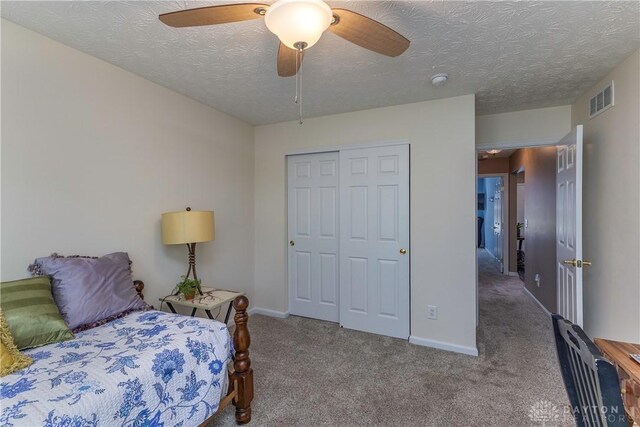 1210 Greystone Cir, Dayton, OH 45414 - bedroom featuring carpet flooring, a closet, a ceiling fan, and a textured ceiling