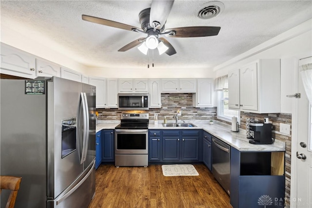 303 Erie Ave, Fairborn, OH 45324 - kitchen with appliances with stainless steel finishes, blue cabinets, ceiling fan, dark wood-type flooring, and light countertops