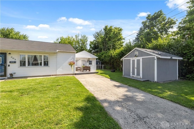 303 Erie Ave, Fairborn, OH 45324 - view of green lawn with driveway and a storage unit