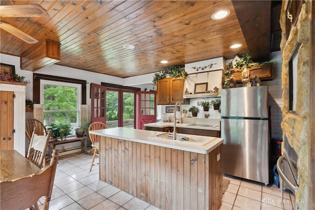 8760 State Route 380, Chester Twp, OH 45177 - kitchen with freestanding refrigerator, light tile patterned flooring, wooden ceiling, light countertops, and a kitchen island with sink