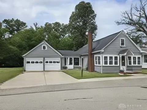 391 N Oak St, Lakeview, OH 43331 - view of front facade with concrete driveway, a garage, and a front yard