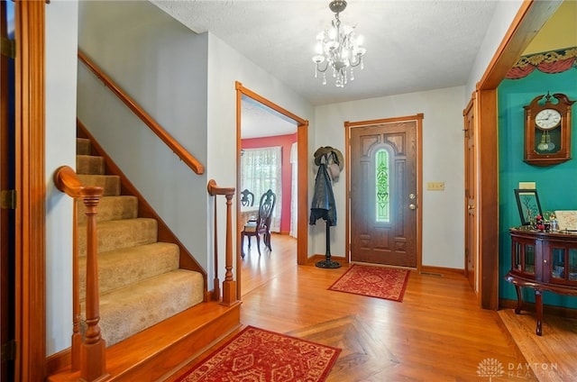 3244 N Shoemaker Rd, Lebanon, OH 45036 - foyer entrance featuring stairs, a chandelier, light wood-type flooring, and a textured ceiling