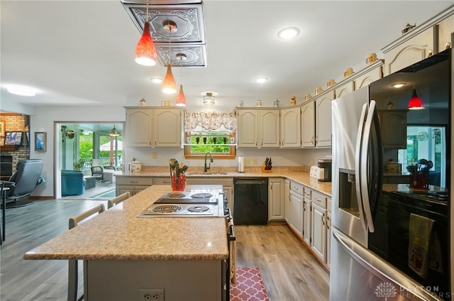 3244 N Shoemaker Rd, Lebanon, OH 45036 - kitchen featuring appliances with stainless steel finishes, cream cabinetry, a kitchen bar, light wood finished floors, and recessed lighting