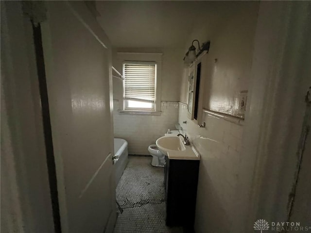 813 S Fred Shuttlesworth Cir, Cincinnati, OH 45229 - full bathroom featuring vanity, a tub to relax in, tile patterned floors, and a wainscoted wall
