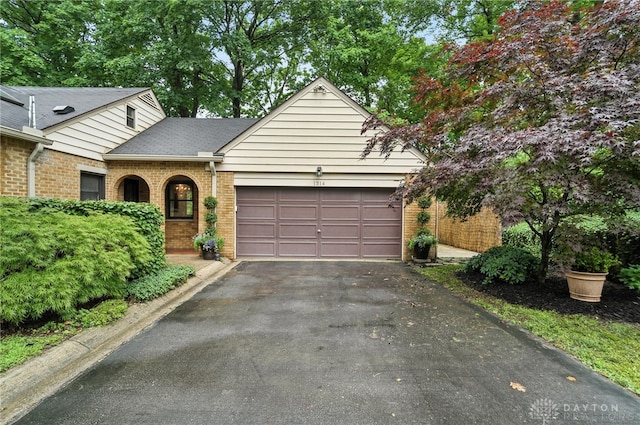 1314 Red Bud Trl, Dayton, OH 45409 - view of front of home featuring brick siding, a garage, driveway, and a shingled roof