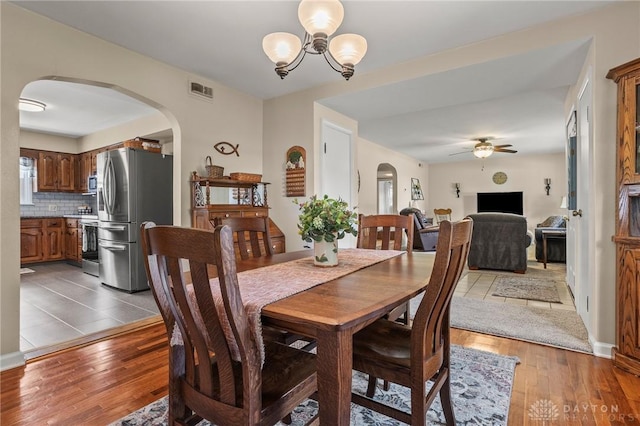 6977 Alternate State Route 49, Arcanum, OH 45304 - dining area featuring arched walkways, a ceiling fan, a chandelier, and wood-type flooring