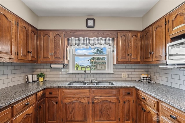 6977 Alternate State Route 49, Arcanum, OH 45304 - kitchen featuring backsplash, stainless steel microwave, and brown cabinets