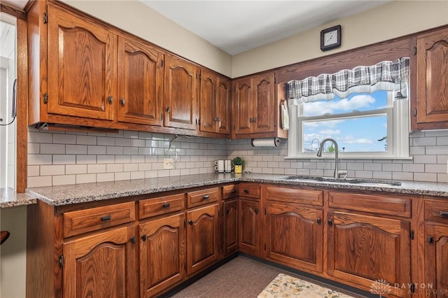 6977 Alternate State Route 49, Arcanum, OH 45304 - kitchen featuring decorative backsplash, light stone counters, brown cabinets, and dark tile patterned flooring