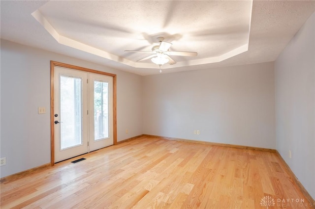 6437 Sun Ridge Dr, Waynesville, OH 45068 - unfurnished room featuring a tray ceiling, light wood-type flooring, and ceiling fan